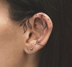 a close up of a person's ear with tattoos on it