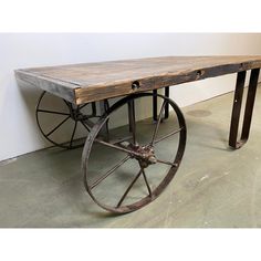 an old wooden table with wheels attached to it