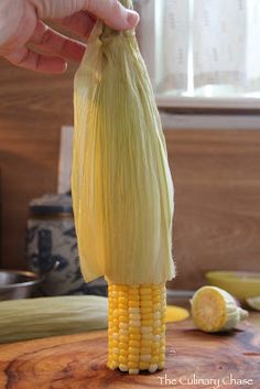 someone is peeling corn on the cob