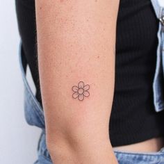 a woman with a small flower tattoo on her arm