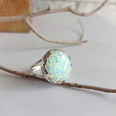 Large silver ring, handcrafted decorated leaves all around set with a delicate lab-grown Opal gemstone, look like a big crown. Gorgeous and full of presence, highlight any outfit you wear. Lab-grown opals usually display a very distinctive snakeskin pattern and they show brighter colors than natural opals. The spots of color are larger but they interact with light in a very similar way to natural opals. Top size: 1.8 inches Stone size: 20mm. Size to order: 5-16 U.S Match necklace: https://www.et Unique Silver Jewelry, White Opal Ring, Ring Opal, Round Rings, Engagement Anniversary, Ring Unique, Opal Ring, Opal Pendants, Natural Opal