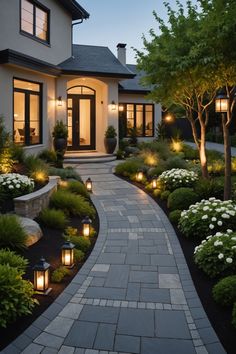 a house that is lit up with lights in the front yard and landscaping around it