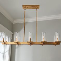 a chandelier hanging from a wooden beam with glass jars on the bottom and sides