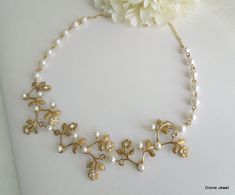 "This necklace is created using gold/brass flower and leaf stampings. Adding to each component Austrian pearls and crystals. Necklace measures approximately 17\" long. Pearls measure 6 mm in diameter and are hand linked and attached to chain to finish the length of this necklace. Focal point measures approximately 5 1/2\" long by 1 1/8\" wide. Finished off with gold plated lobster claw clasp and 2\" extender chain for additional length. Please choose desired pearl color and length at checkout. P Delicate Gold Pearl Bridal Necklace, Delicate Gold Bridal Necklace With Pearls, Delicate Gold Bridal Necklace For Anniversary, Delicate Gold Pearl Wedding Necklace, Delicate Gold Pearl Necklace For Wedding, Gold Pearl Necklace Wedding, Bridal Necklace Gold, Wedding Necklace Pearl, Bridal Necklace Pearl