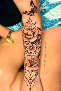 a woman's leg with flowers and butterflies on it