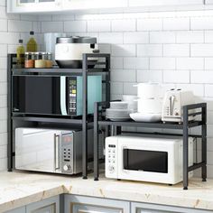 two microwaves are stacked on top of each other in the corner of a kitchen