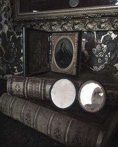 an old book is sitting on top of a shelf with pictures and other items around it