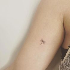 a woman with a small cross tattoo on her arm