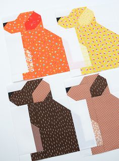 four pieces of paper cut out to look like different dog patterns and colors on them