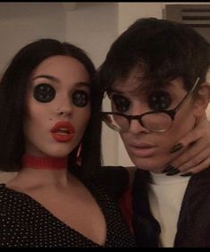 a man and woman are dressed up for halloween with fake eyeballs on their faces