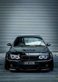 a black car parked in front of a garage door