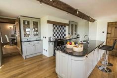 a kitchen with black and white checkerboard backsplash, an island countertop and stools