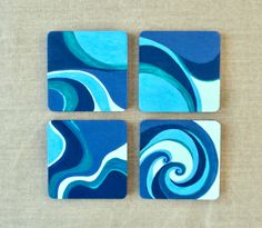 four square coasters with blue and white swirl designs on the top one has a brown background