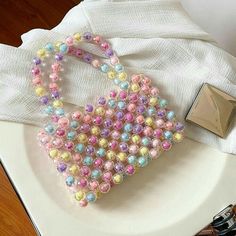 a handbag made out of beads sitting on top of a white plate