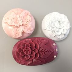 three soaps decorated with flowers and pearls