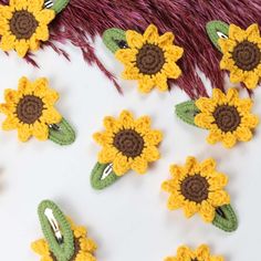 crochet sunflower hair clips in yellow and brown with green leaves on them