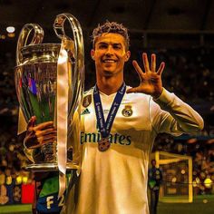 the soccer player is posing with his trophy