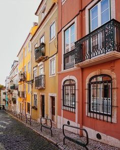 an empty cobblestone street lined with colorful buildings