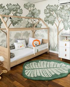 a child's bedroom with a wallpapered forest theme and wooden bed frame