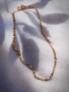 A classic luminescent gold anklet made from 18kt gold filled. The Nanea anklet is a stunning addition to your collection. The lines of this piece are elegant, shimmery, and the perfect dainty adornment for summer days. ✦ DETAILS ✦✧ Name: Nanea - (nah neh ah) - fascinating.✧ Adjustable Length up to 10" inches.✧ 18kt Gold Filled.✧ You will receive 1 anklet.✧ All Ke Aloha Jewelry pieces come packaged thoughtfully, beautifully, and ready for gift giving. Minimalist Gold Chain Anklets, Dainty Gold Bracelet With Figaro Chain, Gold Tarnish Resistant Anklets For Gifts, Dainty Gold Anklets Tarnish Resistant, Dainty Gold Figaro Chain Bracelet, Skin-friendly Gold Minimalist Anklet, Dainty Gold Anklet With Delicate Chain, Gold Chain Anklets As Gift, Gold Chain Anklet Gift