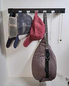 three hats hanging from hooks on a wall