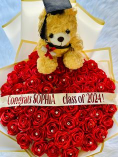 a teddy bear sitting on top of a heart shaped rosette bouquet with congratulations sophia class of 2014