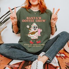 Santa's Coffee Crew Christmas shirt - Comfort colors christmas shirt Get into the holiday spirit with our "Santa's Coffee Crew" Comfort Colors T-Shirt! This festive tee is perfect for coffee lovers who want to keep their Christmas season perky and bright. Made with the high-quality, super-soft fabric that Comfort Colors is known for, this shirt will quickly become your favorite go-to for cozy winter days. Key Features: Brand: Comfort Colors Sleeves: Short sleeves. Neck: Crew neck. Style: Vintage Christmas Cookie Shirt, Cookie Shirt, Coffee Shirts, Christmas Coffee, Winter Days, Christmas Cookie, Christmas Tees, Cozy Winter, Christmas Png