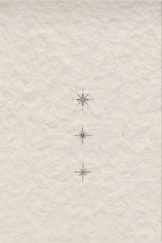 three snowflakes are shown in the middle of a white paper sheet with black ink