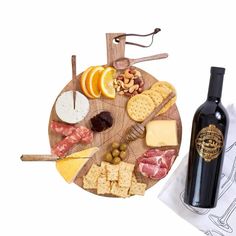 an assortment of cheeses, crackers, and wine on a wooden platter