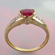 A vibrant natural ruby is centered on this attractive 14k yellow gold diamond ring. The .58 carat oval faceted ruby is of deep raspberry pinkish-red color. It measures 6mm x 4.2mm x 2.9mm and is tightly held by two half-bezels.  Three bright and sparkly 1.5mm diamonds flank the red gem on its shoulders (six total). Each profile side of the ring is also bezel set with a tiny 0.9mm diamond. So, no matter what angle you are looking at the ring you will see a gemstone sparkle. Collectively, the ring Oval Ruby Ring With Diamond Accents For Promise, Oval Ruby Birthstone Ring With Diamond Accents, Red Oval Diamond Ring With Accents, Oval Red Diamond Ring With Accents, Red Oval Brilliant Cut Birthstone Ring, Oval Ruby Ring Stamped 14k, Red Ruby Ring With Diamond Accents In 14k Gold, Yellow Gold Ruby Ring With Diamond Accents, Red Birthstone Ring With Brilliant Oval Cut