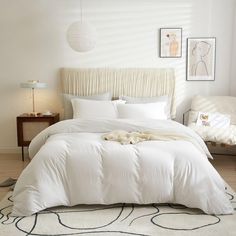 a bed with white sheets and pillows in a bedroom