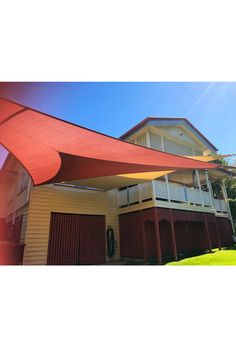 a house with a large red awning over it's front porch and garage