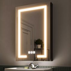 a bathroom sink sitting under a mirror with lights on it's sides and a potted plant in the corner