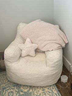 a white bean bag chair sitting on top of a wooden floor next to a wall