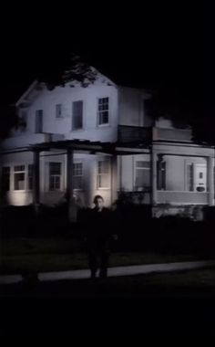 a person standing in front of a house at night