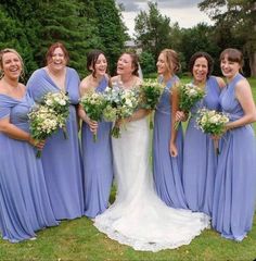 a group of women standing next to each other on top of a lush green field