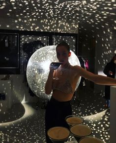 a woman taking a selfie in front of a disco ball