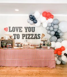 a table topped with lots of balloons next to a sign that says love you to pizzas