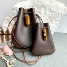 "Vegan Eco Leather Medicine Bag, Shaman Bag or Amulet Pouch to wear around your neck-or hang in your Car! Perfect for Ceremony or for Festival Wear. Dark Chocolate Faux Leather with a Tiger Eye Healing Stone Point. The Large size has a Double Terminated Stone! Unique and Beautiful Gift . A place for things that have Spiritual Meaning for you-like that pretty rock your 3 year old gave you.... Two Choices: Small:3 3/4\"deep 2 3/4\"wide Large:5 1/4\"deep 4\"wide BUY ANY 4 MEDICINE BAGS(VEGAN LEATHE Faux Leather Satchel Shoulder Bag Gift, Brown Rectangular Pouch For Personal Use, Everyday Portable Brown Pouch, Brown Bag With Dust Bag As A Gift, Brown Everyday Pouch, Small Brown Bags For Everyday Use, Leather Coin Purse In Pouch Shape, Faux Leather Crossbody Bag Gift, Faux Leather Crossbody Bag For Gift