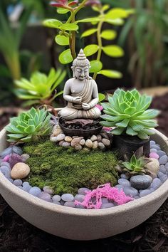 a buddha statue sitting on top of a bowl filled with rocks and succulents