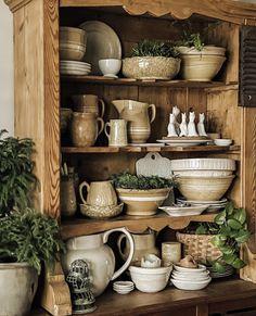 a wooden shelf filled with lots of dishes