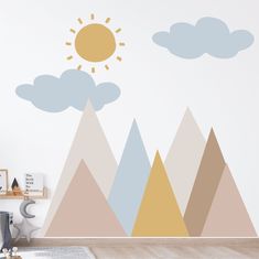 a wall with mountains and clouds painted on it in a child's playroom