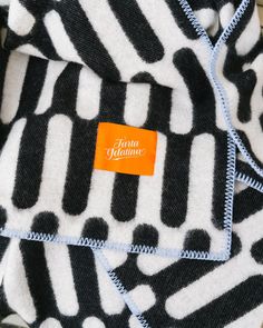 an orange label is on the black and white patterned towel that has been folded over