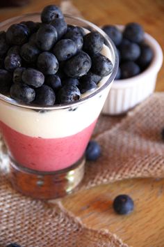 blueberries and yogurt sit in small cups on a table with burlocks