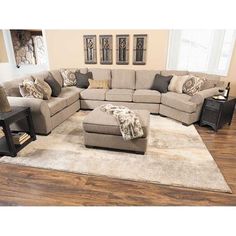 a living room filled with furniture on top of a hard wood floor covered in rugs