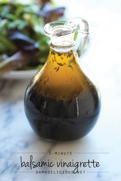 a bottle of balsamic vinegar next to a salad