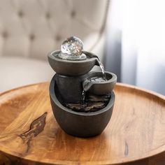 a water fountain sitting on top of a wooden table