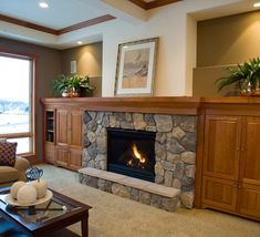 a living room filled with furniture and a fire place in front of a large window