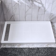 a white shower stall with grey carpet and tile walls