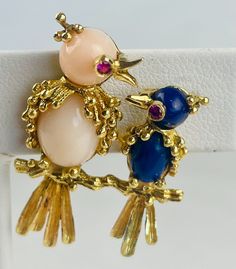 Lovely, vintage 18k yellow gold, lapis lazuli, coral and red stone brooch. A mother bird with a white coral body sits on a branch with her lapis lazuli baby. Both birds have ruby eyes. The piece measures 1.28 inches (l) by 0.87 inches (w) and has a total gross weight of 7.50 grams. The piece is stamped 18k and FC, though the maker's signature is unclear. Check out our eBay store, Donna's Jewelry Room, for many more listings! Fine Jewelry Brooch For Collectors, Fine Jewelry Brooch, Collectible Fine Jewelry Brooch, Elegant Multi-stone Brooches For Gifts, Fine Jewelry Multi-stone Yellow Gold Brooches, Elegant Multi-stone Collectible Brooches, Fine Jewelry Yellow Gold Multi-stone Brooches, Exquisite Collectible Jewelry Brooch, Exquisite Collectible Brooch Jewelry